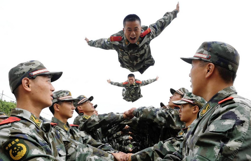 Paramilitary policemen jump up above their fellow policemen's arms during a psychological training in Tongling