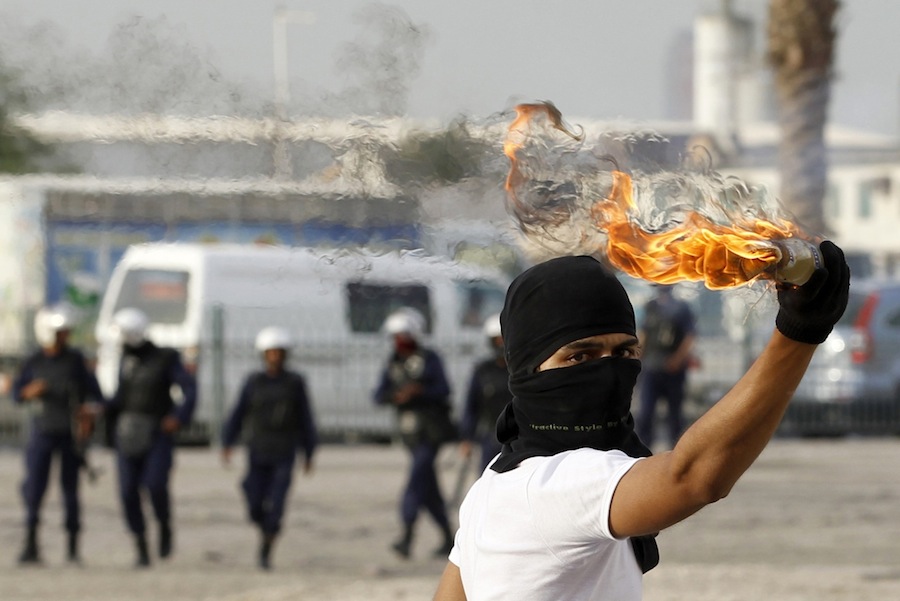 An anti-government protester throws a molotov cocktail at riot-police during clashes at the mourning procession of the murdered Ahmed Ismael Abdulsamad in the village of Salmabad