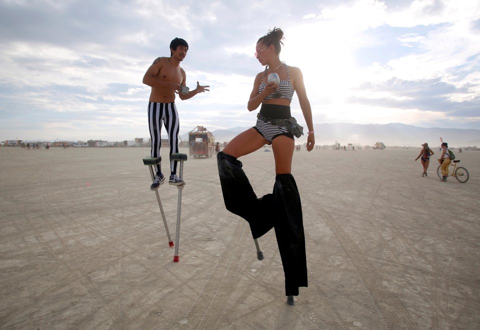 Divine Mustache and Katapult Sandra, their Playa names, dance on stilts as approximately 70,000 people from all over the world gather for the 30th annual Burning Man arts and music festival in the Black Rock Desert of Nevada, U.S.